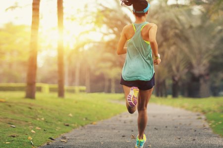 healthy lifestyle young sporty asian woman running at tropical park